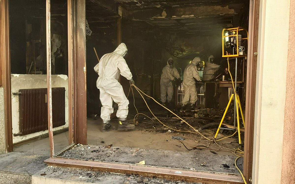 Aufraeumarbeiten feuerwehrleute mit schutzanzuegen Aufraeumarbeiten feuerwehrleute mit schutzanzuegen