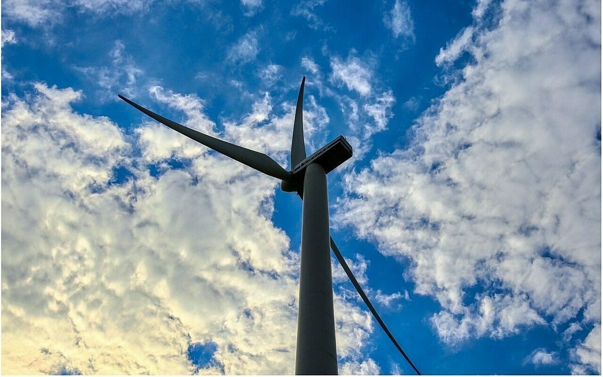 Ein windrad vor einem blauen himmel voller wolken Ein Windrad vor einem blauen Himmel voller Wolken