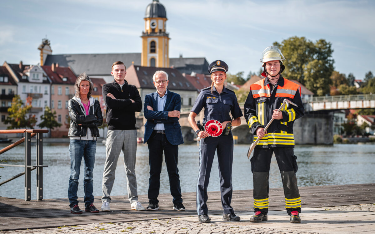Bürger und Blaulichtkräfte stehen vor dem Main, im Hintergrund ist die Kitzinger Innenstadt zu erkennen Bürger und Blaulichtkräfte stehen vor dem Main, im Hintergrund ist die Kitzinger Innenstadt zu erkennen