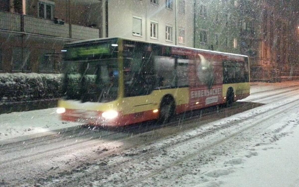 Ein Würzburger Stadtbus fährt über eine verschneite Straße Bus Schnee