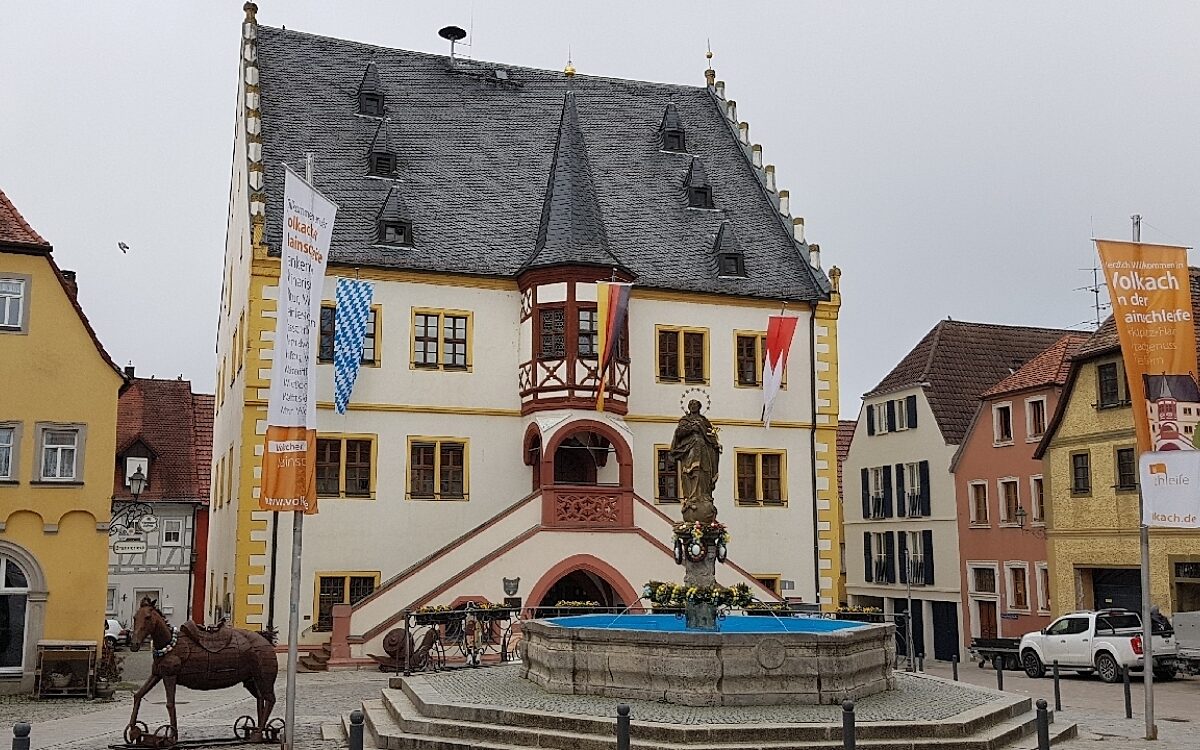 Das ist das Rathaus von Volkach mit Brunnen im Vordergrund bei bewölktem Himmel Das ist das Rathaus von Volkach mit Brunnen im Vordergrund bei bewölktem Himmel
