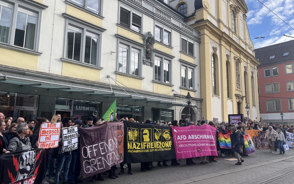 Demonstranten stehen mit Plakaten auf der Gegenseite Demonstranten stehen mit Plakaten auf der Gegenseite