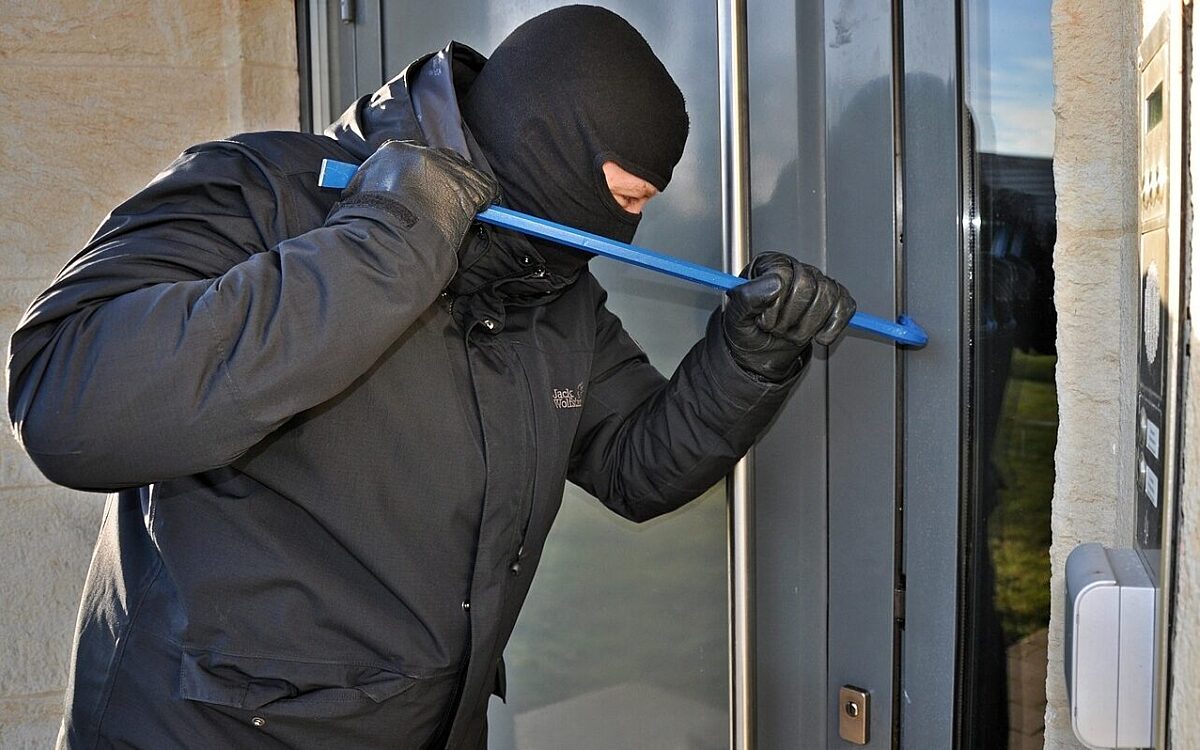 Ein Einbrecher bricht in ein Haus ein