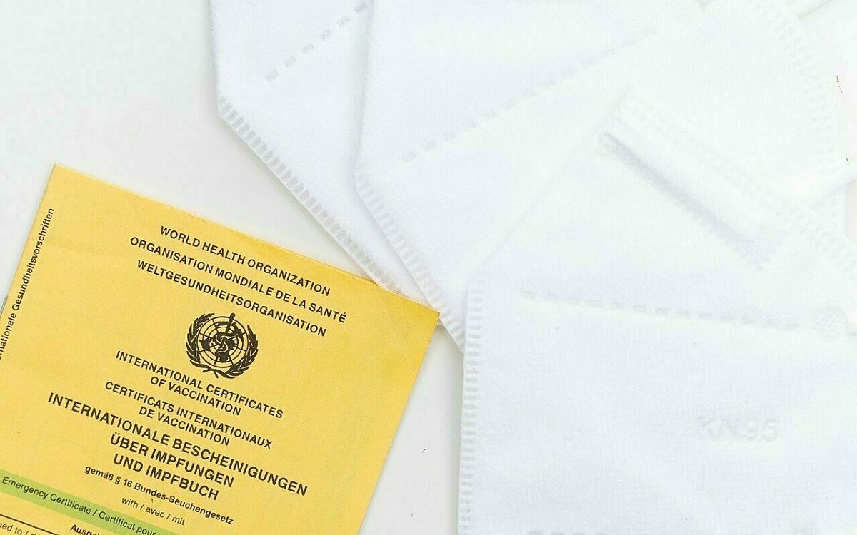 Ein Impfpass liegt neben mehreren FFP2 Masken Ein Impfpass liegt neben mehreren FFP2 Masken