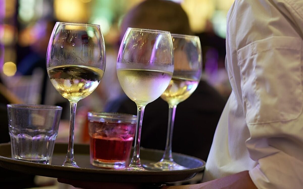 Ein Kellner serviert Wein und Schnaps Ein Kellner serviert Wein und Schnaps