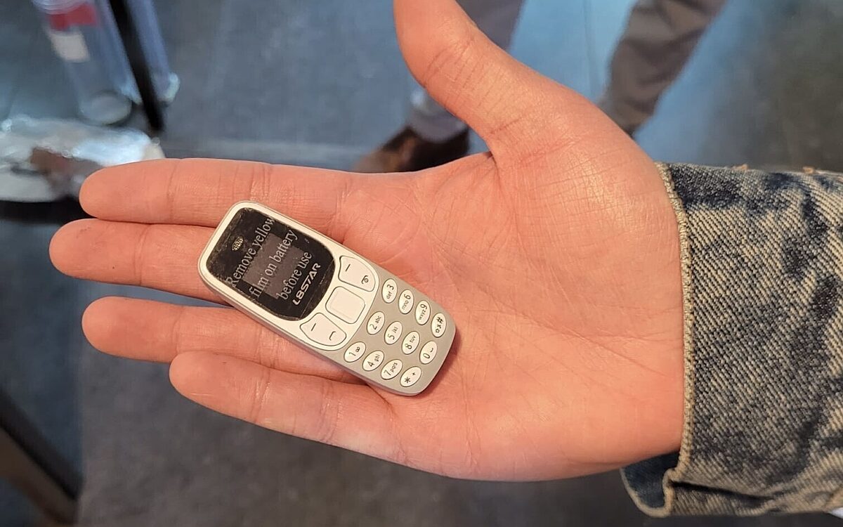 Ein Minihandy auf einer Hand Ein Minihandy auf einer Hand