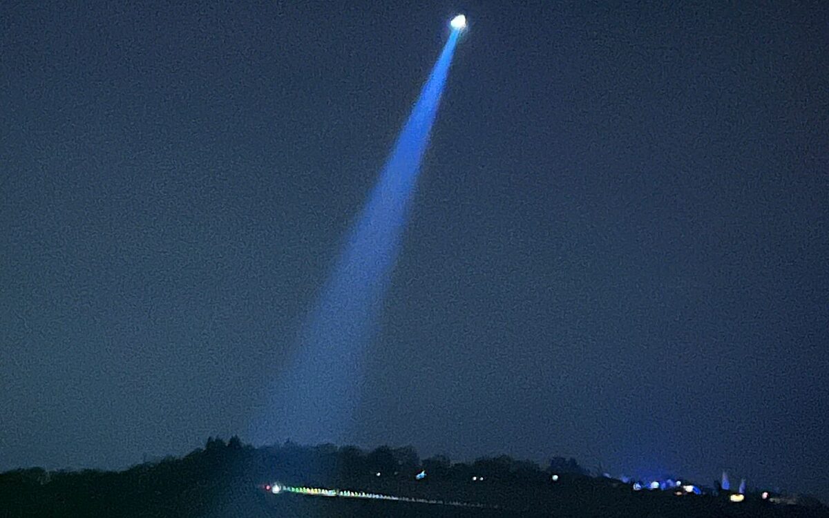 Ein Polizeihubschrauber sucht mit Scheinwerfer in der Nacht Ein Polizeihubschrauber sucht mit Scheinwerfer in der Nacht