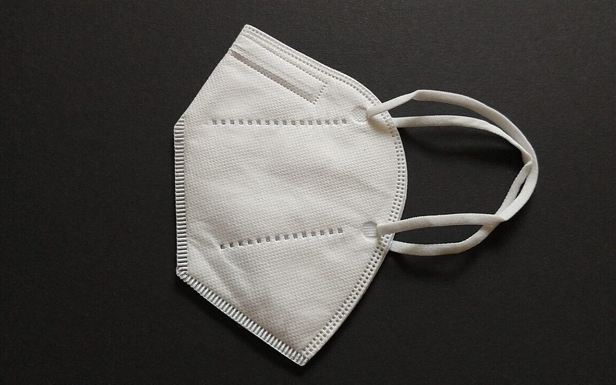 Eine FFP2 Maske vor einem schwarzen Hintergrund Eine FFP2 Maske vor einem schwarzen Hintergrund