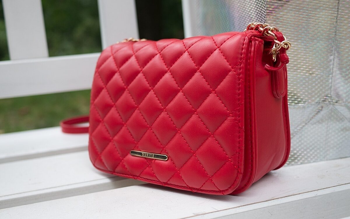 Eine pinke Handtasche steht auf einer Bank Eine pinke Handtasche steht auf einer Bank