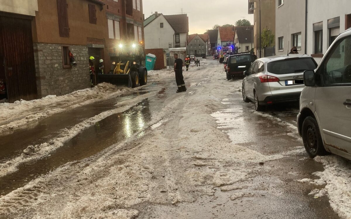 In Birkenfeld räumt ein Radlader Hagelkörner von der Straße In Birkenfeld räumt ein Radlader Hagelkörner von der Straße