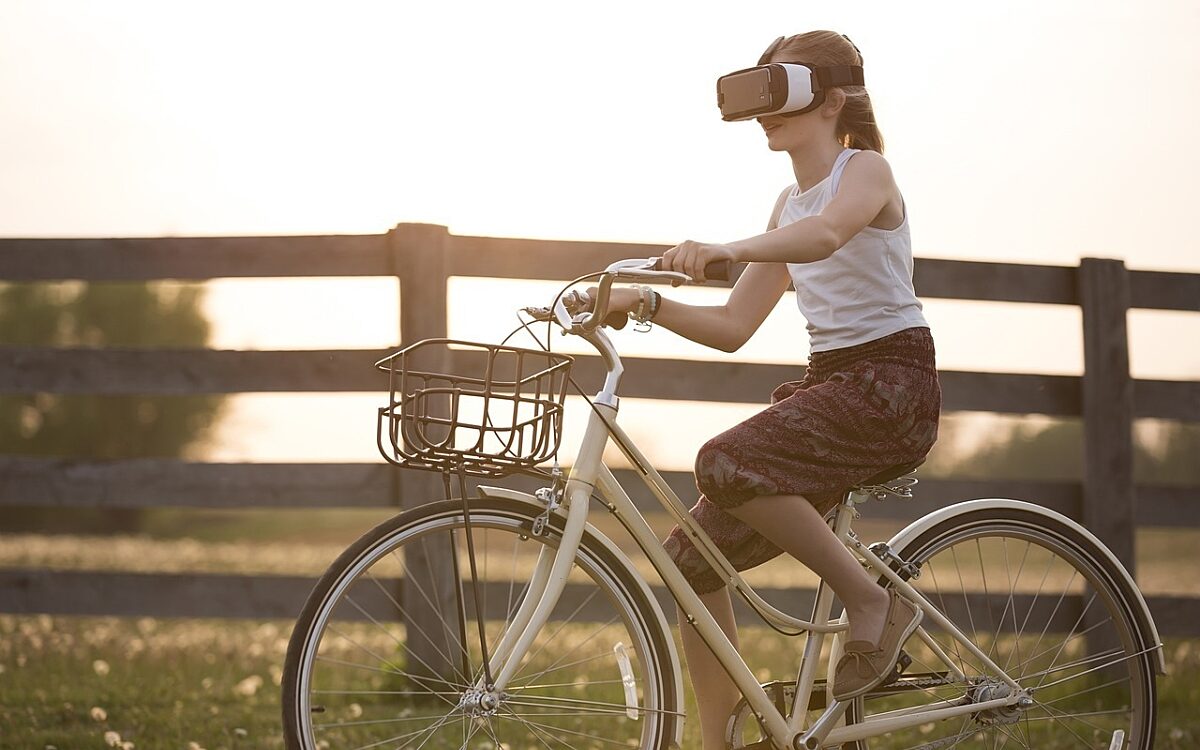 Ein Kind fährt Fahrrad und trägt dabei eine VR-Brille Ein Kind fährt Fahrrad und trägt dabei eine VR-Brille