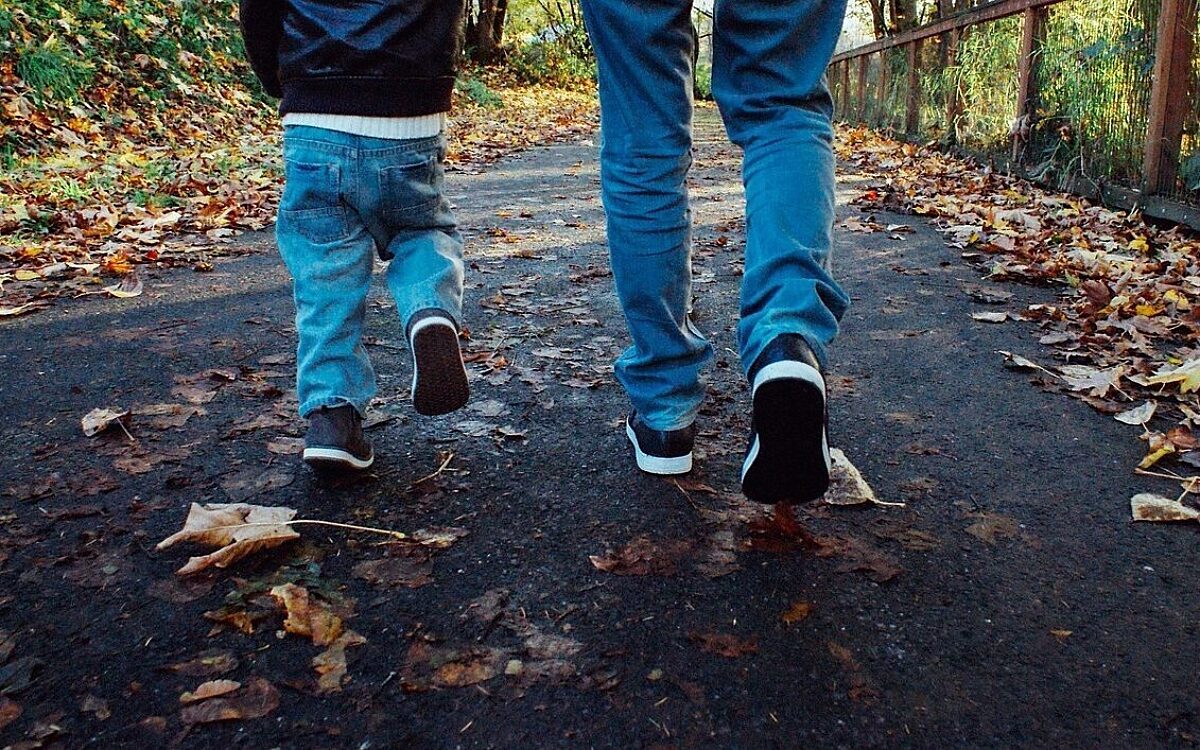 Vater und Sohn gehen durch Laub Spazieren Familie Vater und Sohn gehen durch Laub Spazieren Familie