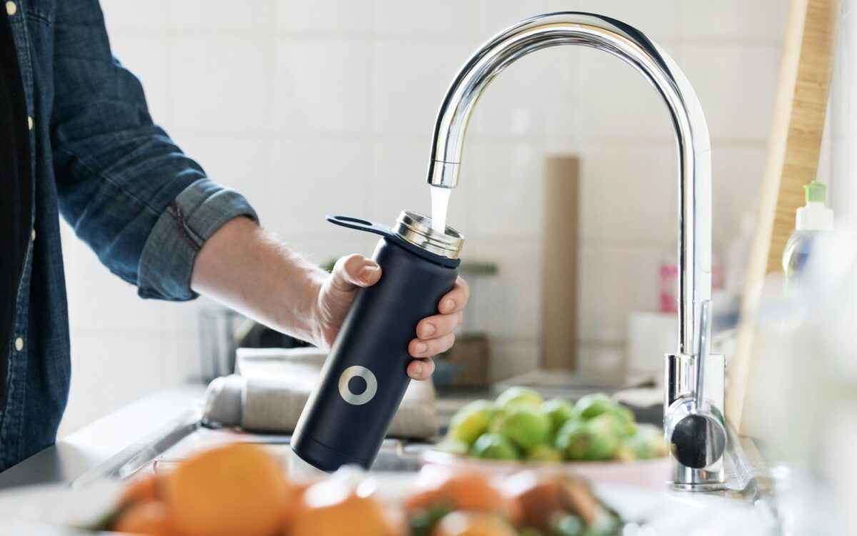 Wasserhahn Flasche mit Wasser gefüllt Wasserhahn Flasche mit Wasser gefüllt