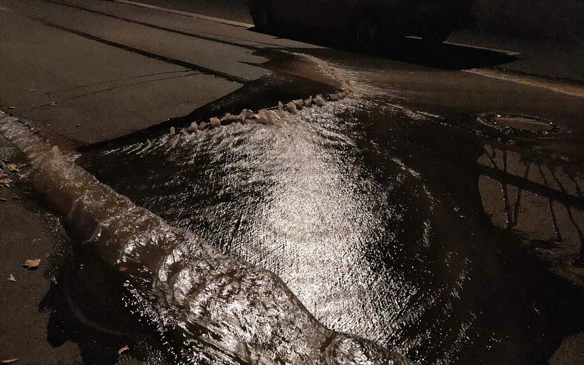 Nach einem Wasserrohrbruch steht Wasser auf der Straße Nach einem Wasserrohrbruch steht Wasser auf der Straße