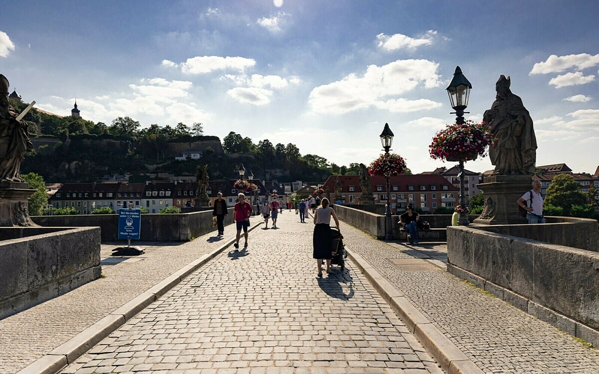 Alte Mainbrücke Wuerzburg mit Blick stadtauswärts und Fußgänger Alte Mainbrücke Wuerzburg mit Blick stadtauswärts und Fußgänger