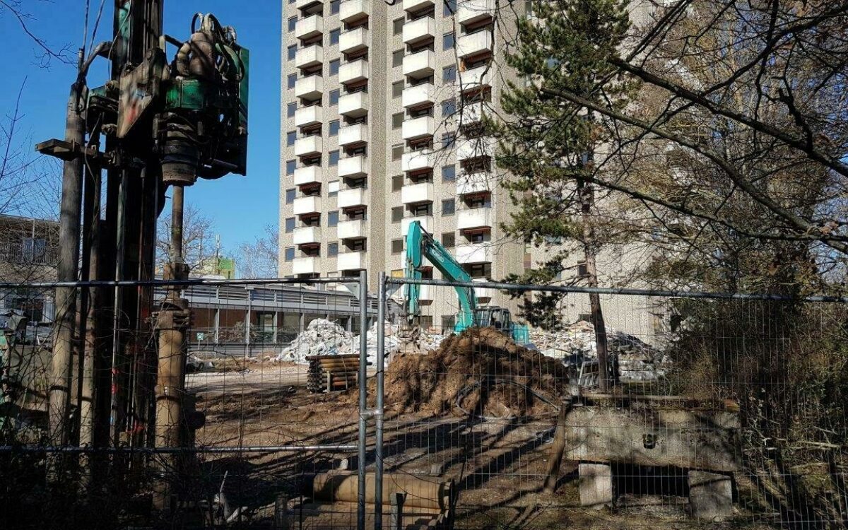 Baustelle vor dem Hochhaus im Stadtteil Sanderau in Würzburg Bauzaun dahinter Erdhaufen und Bagger Baustelle vor dem Hochhaus im Stadtteil Sanderau in Würzburg Bauzaun dahinter Erdhaufen und Bagger