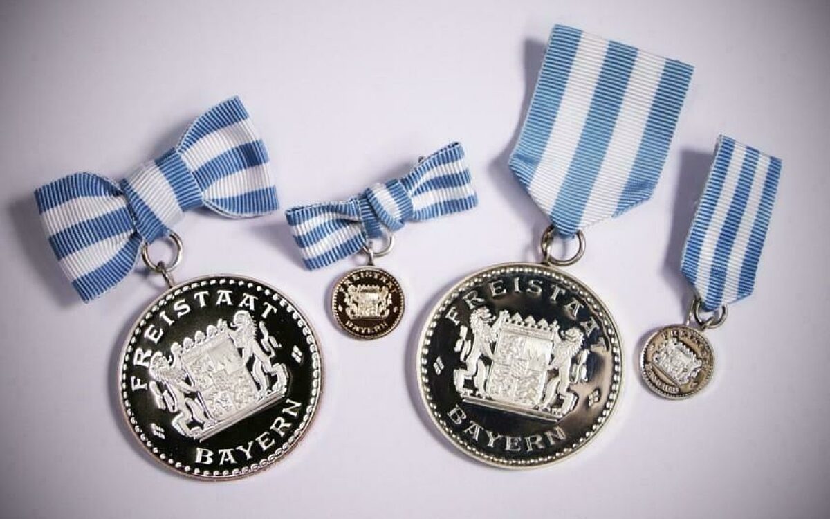 Die Bayerische Rettungsmedaille. Die Version für Frauen hängt an einer Schleife, die für Männer an einem Band. Die Bayerische Rettungsmedaille. Die Version für Frauen hängt an einer Schleife, die für Männer an einem Band.