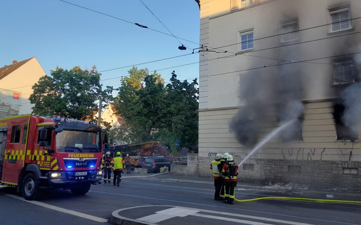 Die Feuerwehr hält den Wasserstrahl in das Fenster einer Wohnung, aus dem es stark qualmt. Die Feuerwehr hält den Wasserstrahl in das Fenster einer Wohnung, aus dem es stark qualmt.
