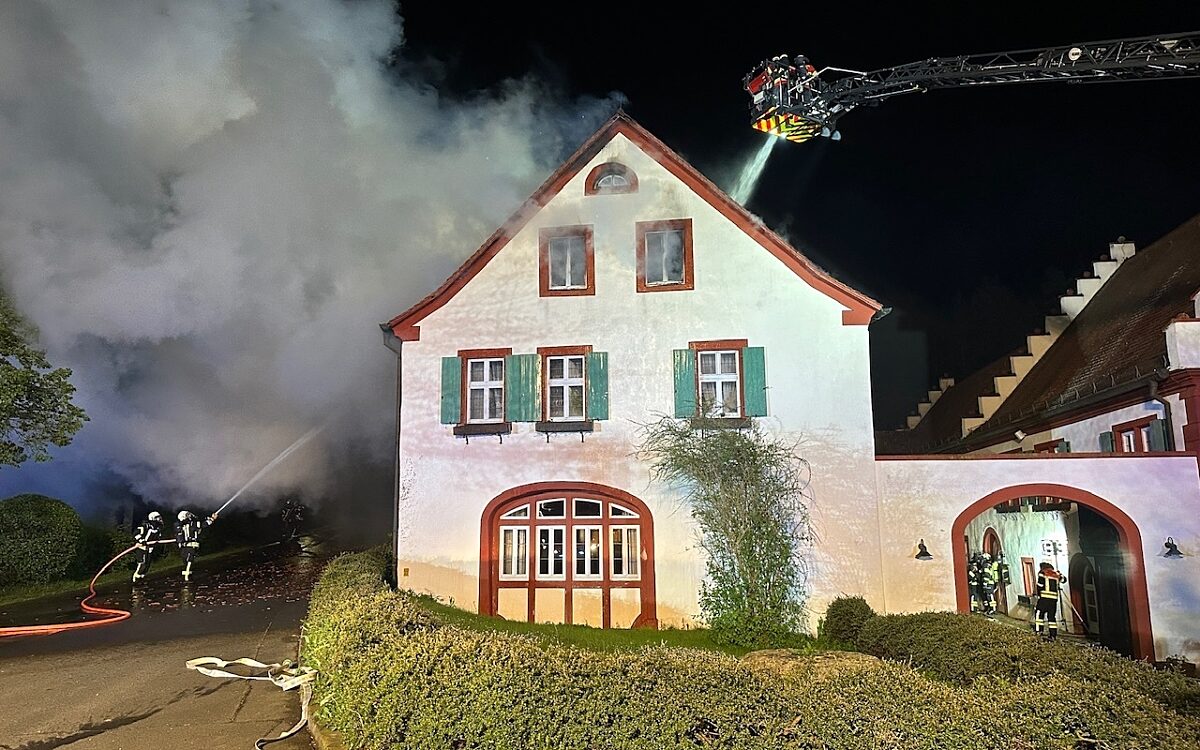 Eine Drehleiter der Feuerwehr steht neben der Weißen Mühle und Feuerwehrleute löschen den Dachstuhl Eine Drehleiter der Feuerwehr steht neben der Weißen Mühle und Feuerwehrleute löschen den Dachstuhl