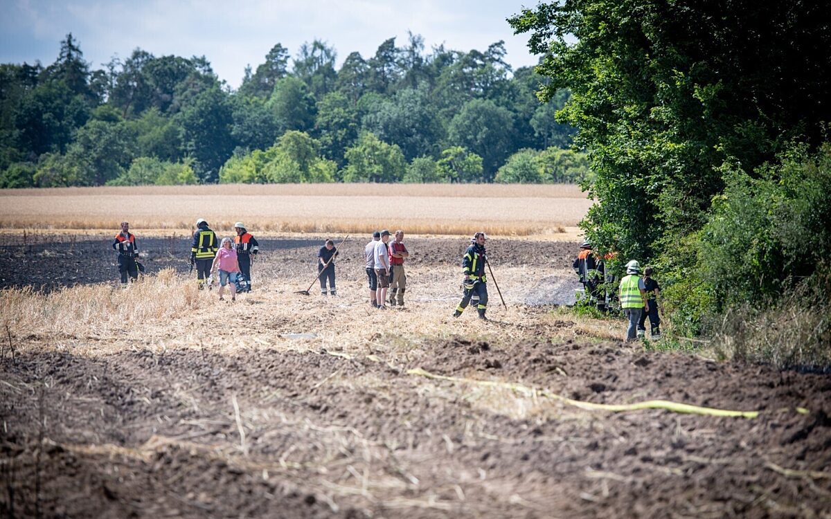 Die Feuerwehr auf einem abgebrannten Feld Die Feuerwehr auf einem abgebrannten Feld