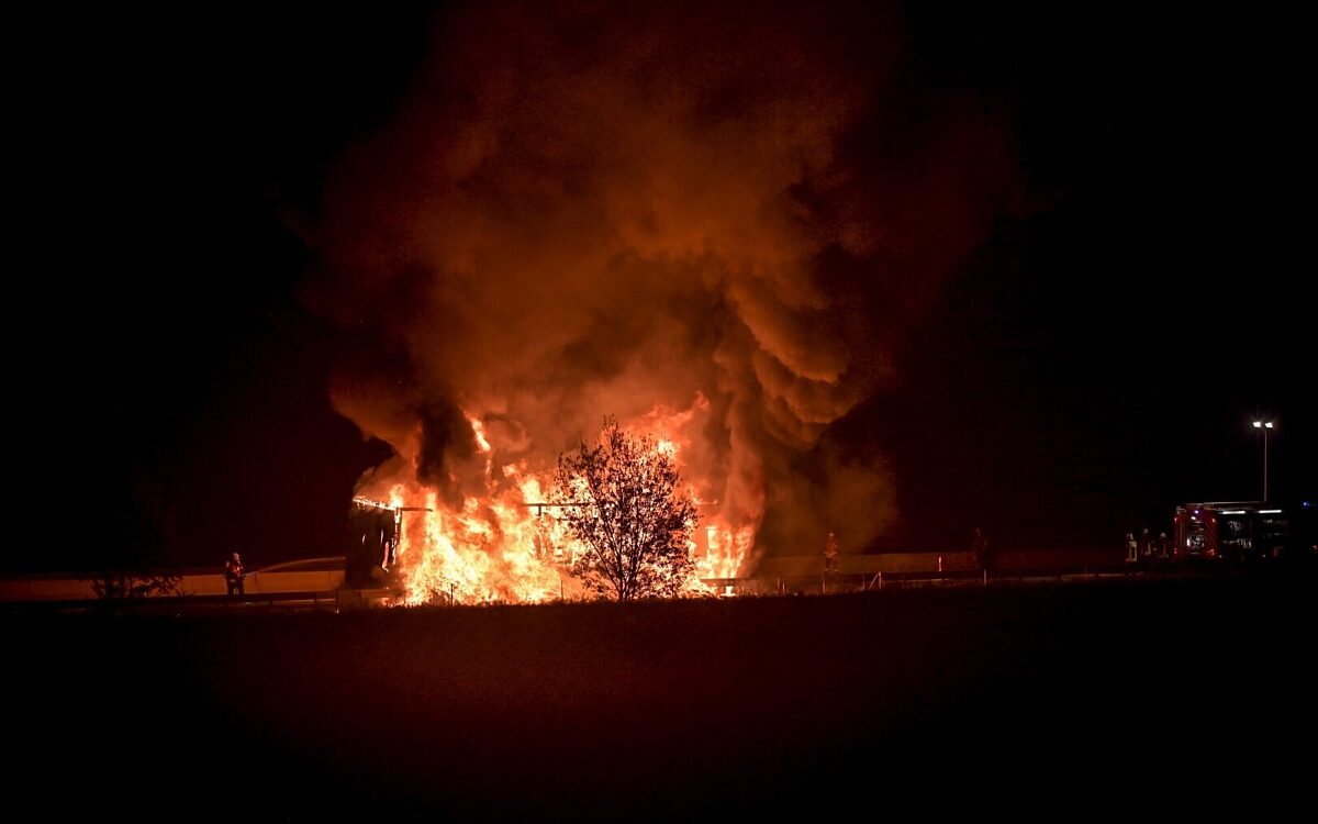 Der Brand des LKW aus der Ferne. Es ist dunkel, in der Mitte lodern die Flammen Der Brand des LKW aus der Ferne. Es ist dunkel, in der Mitte lodern die Flammen