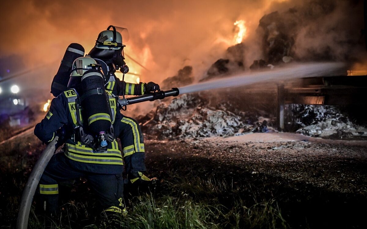 Ein Feuerwehrmann löscht die Flammen des LKW Ein Feuerwehrmann löscht die Flammen des LKW