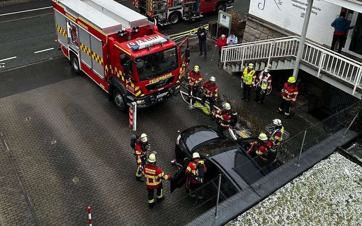 Die Feuerwehr steht um das Auto das in einer Tiefgarage gebrannt hatte. Die Feuerwehr steht um das Auto das in einer Tiefgarage gebrannt hatte.