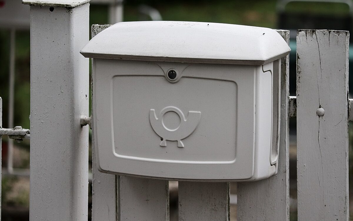 Ein Briefkasten hängt an einem Zaun Ein Briefkasten hängt an einem Zaun