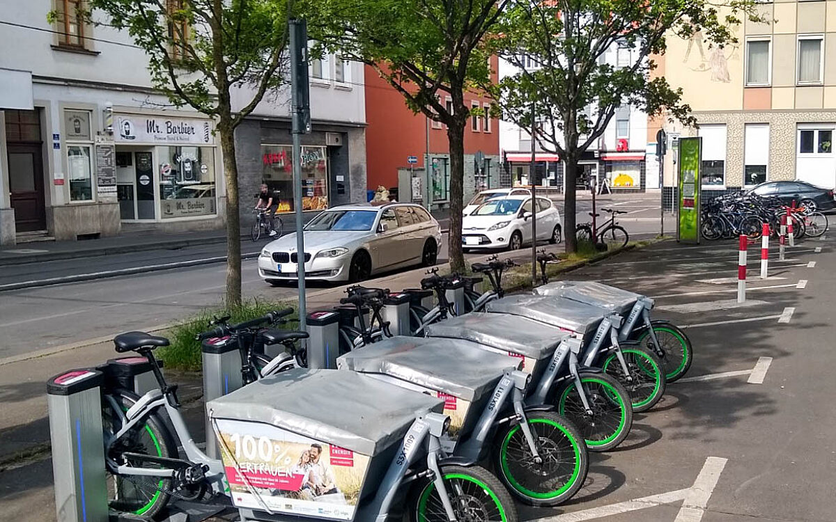 Mehrere E-Lastenräder zum Mieten stehen geparkt an einer Ausleihstation Mehrere E-Lastenräder zum Mieten stehen geparkt an einer Ausleihstation