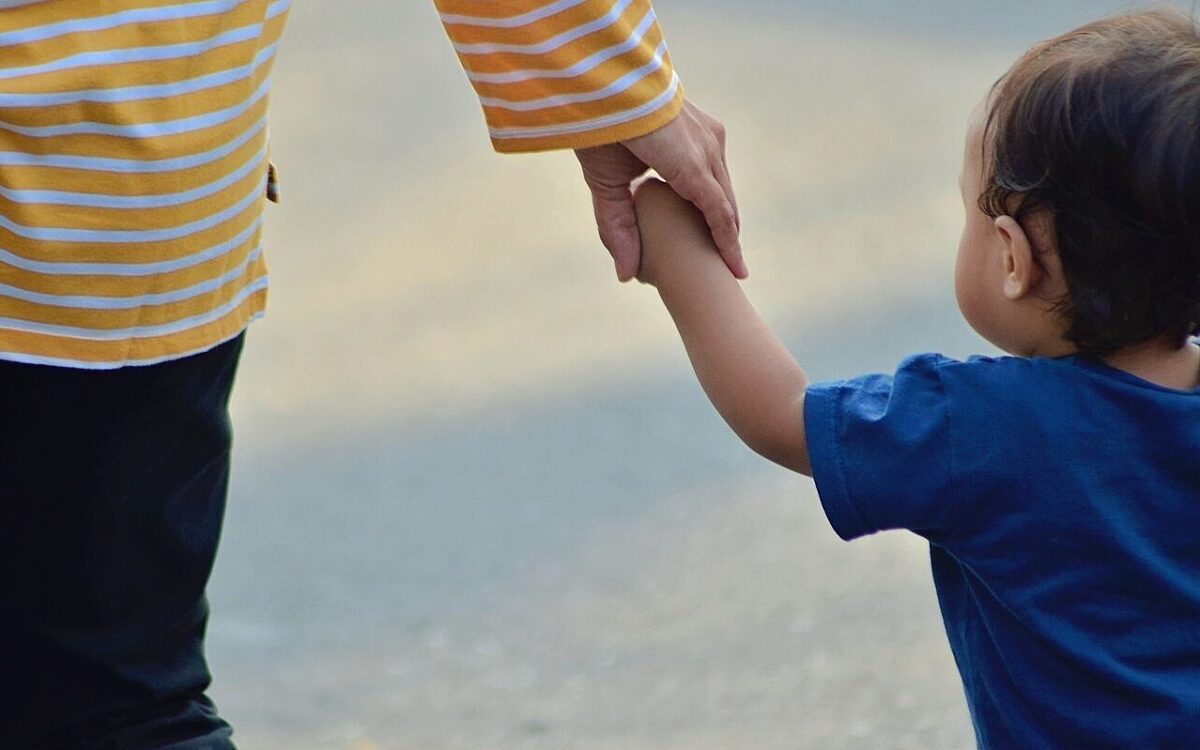Ein Kleinkind läuft an der Hand Ein Kleinkind läuft an der Hand