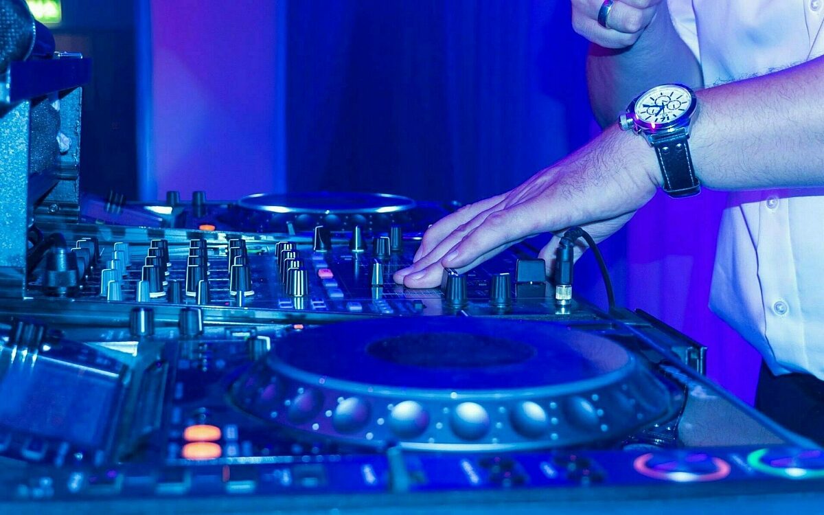 Ein DJ-Pult in einem Club Ein DJ steht an einem DJ-Pult