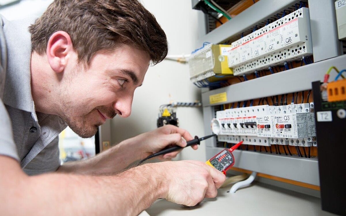 Ein Elektroniker / Handwerker bei der Arbeit Ein Elektroniker / Handwerker bei der Arbeit