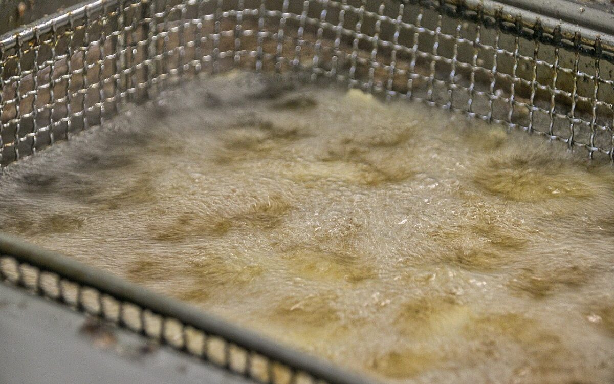 Fett sprudelt in einer Fritteuse Fett sprudelt in einer Fritteuse