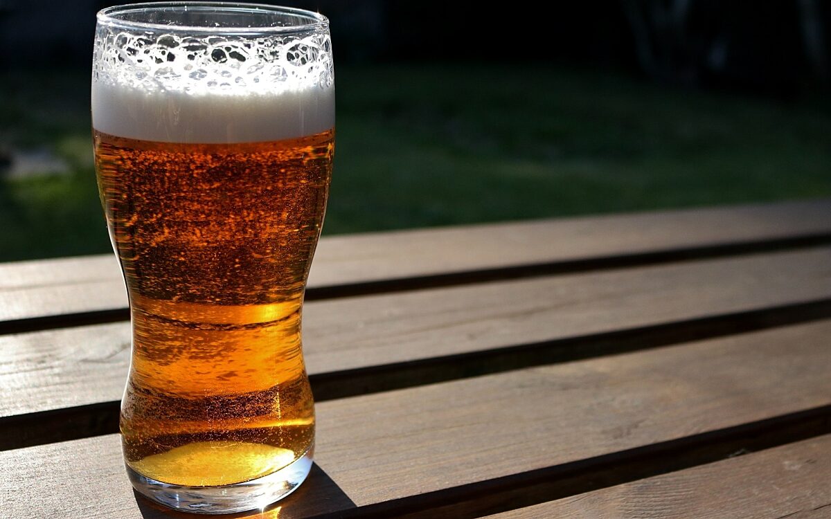 Ein Glas Bier / Alkohol auf einem Tisch in der Sonne Ein Glas Bier / Alkohol auf einem Tisch in der Sonne