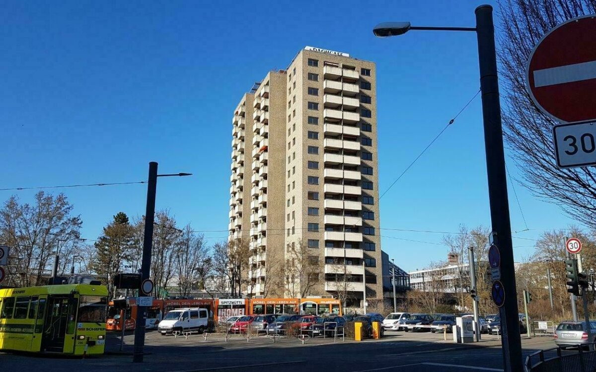 Hochhaus im Stadtteil Sanderau in Würzburg mit Dachcafe im Vordergrund Straßenbahnen und Parkplätze Hochhaus im Stadtteil Sanderau in Würzburg mit Dachcafe im Vordergrund Straßenbahnen und Parkplätze