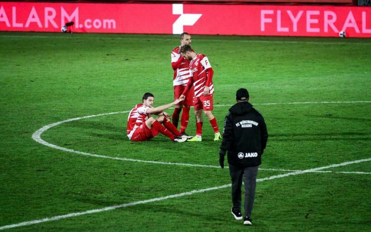 Ein Kickers-Spieler sitzt betrübt am Boden Ein Kickers-Spieler sitzt betrübt am Boden