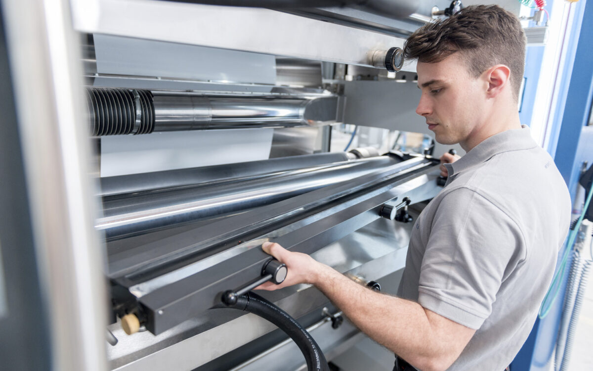 Ein Mitarbeiter von Koenig&Bauer steht vor einer Maschine Ein Mitarbeiter von Koenig&Bauer steht vor einer Maschine