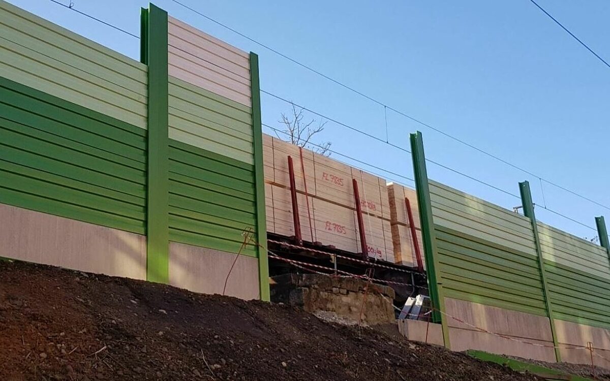 Eine Lärmschutzwand der Deutschen Bahn entlang der Gleise in grün und braun Eine Lärmschutzwand der Deutschen Bahn entlang der Gleise in grün und braun