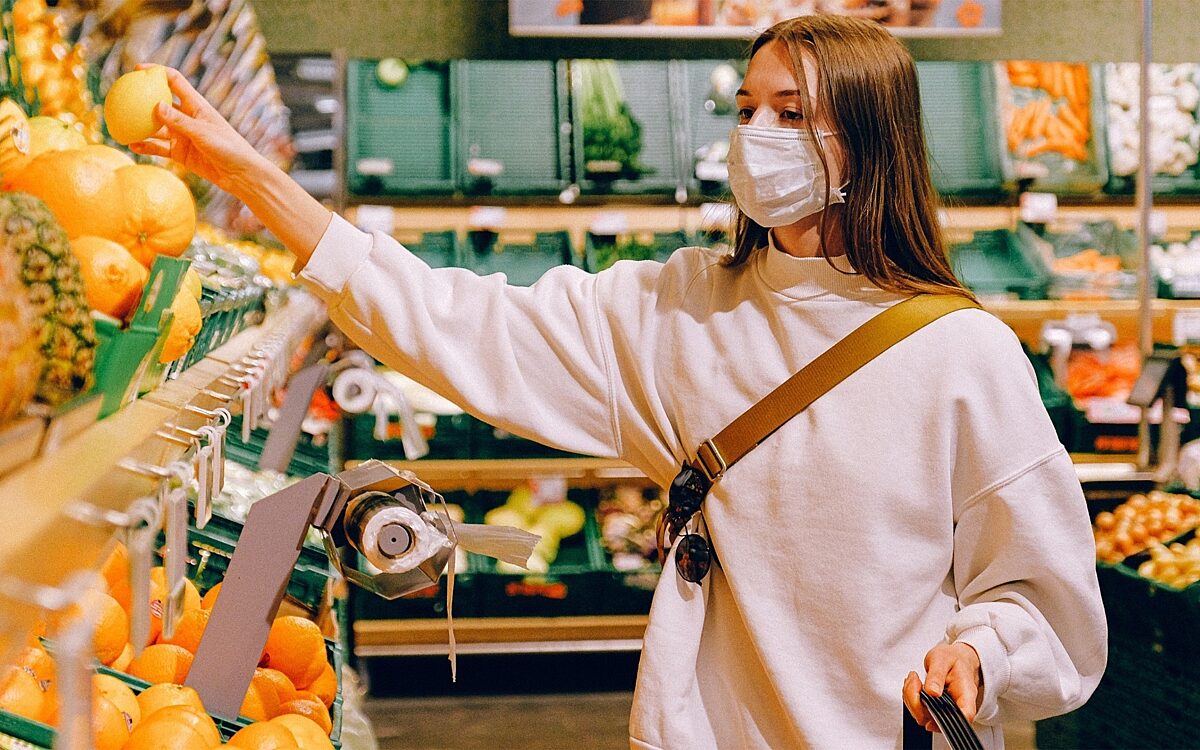 Eine Frau trägt eine Maske beim Einkauf Eine Frau trägt eine Maske beim Einkauf