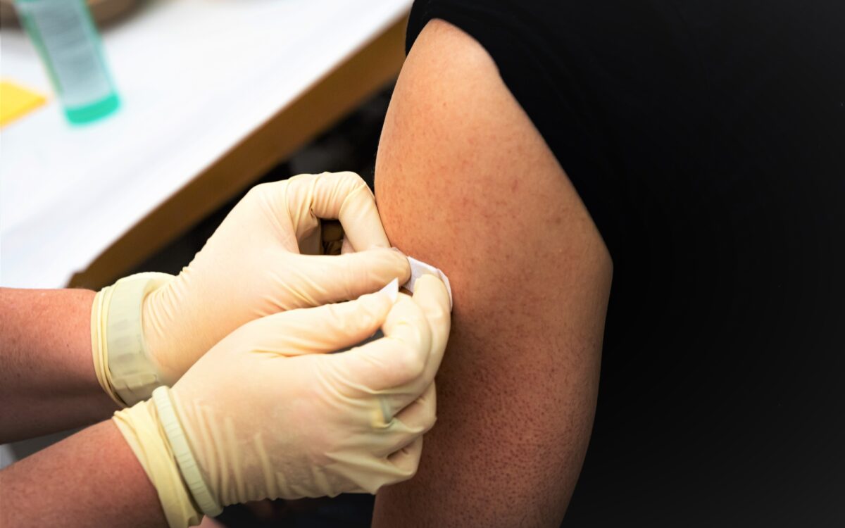 Nach der Impfung bekommt eine Person ein Pflaster Nach der Impfung bekommt eine Person ein Pflaster