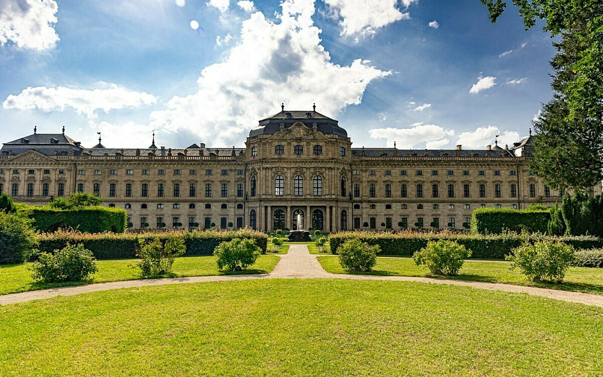 Residenz Würzburg frontal vom Residenzgarten mit Wolken bei Sonnenschein Residenz Würzburg frontal vom Residenzgarten mit Wolken bei Sonnenschein