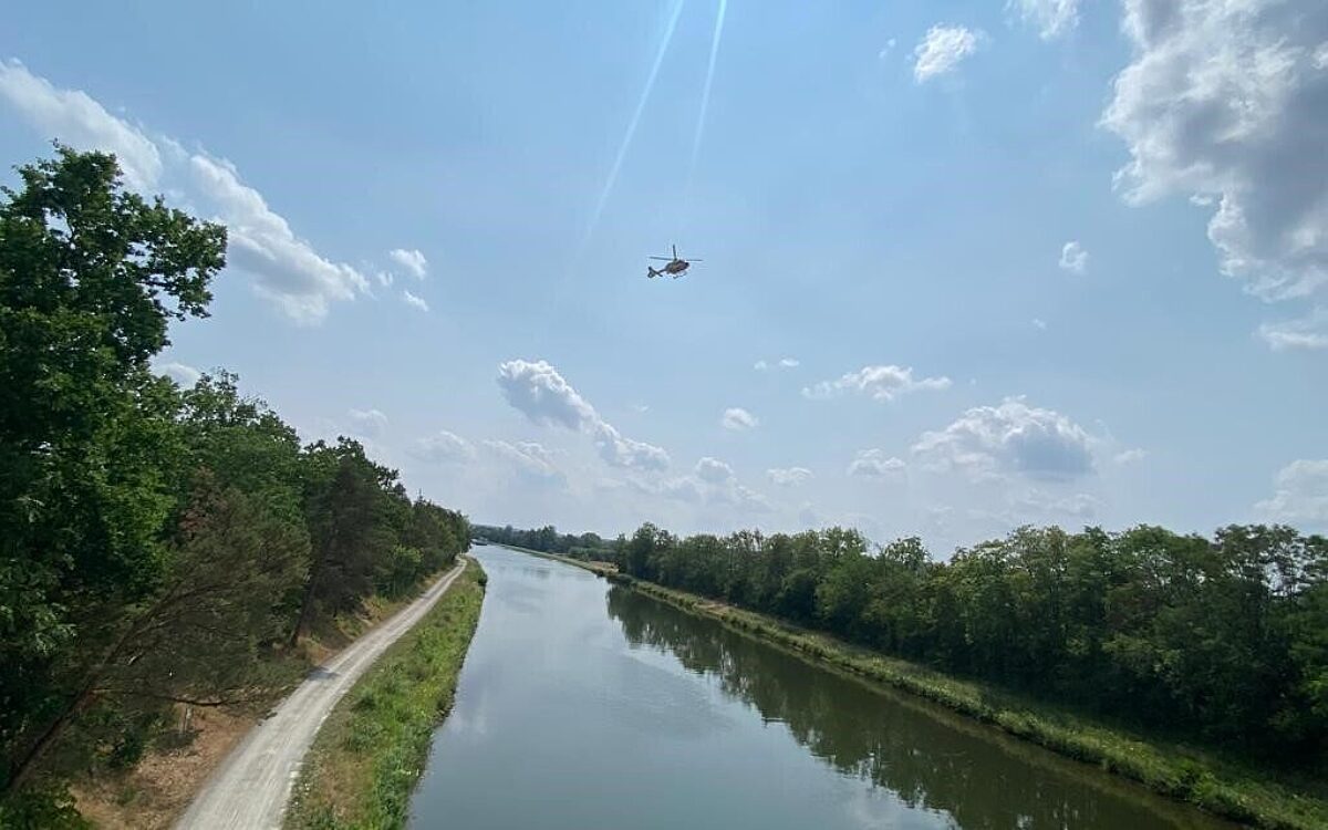 Ein Rettungshubschrauber schwebt für eine Personensuche über dem Main Ein Rettungshubschrauber schwebt für eine Personensuche über dem Main
