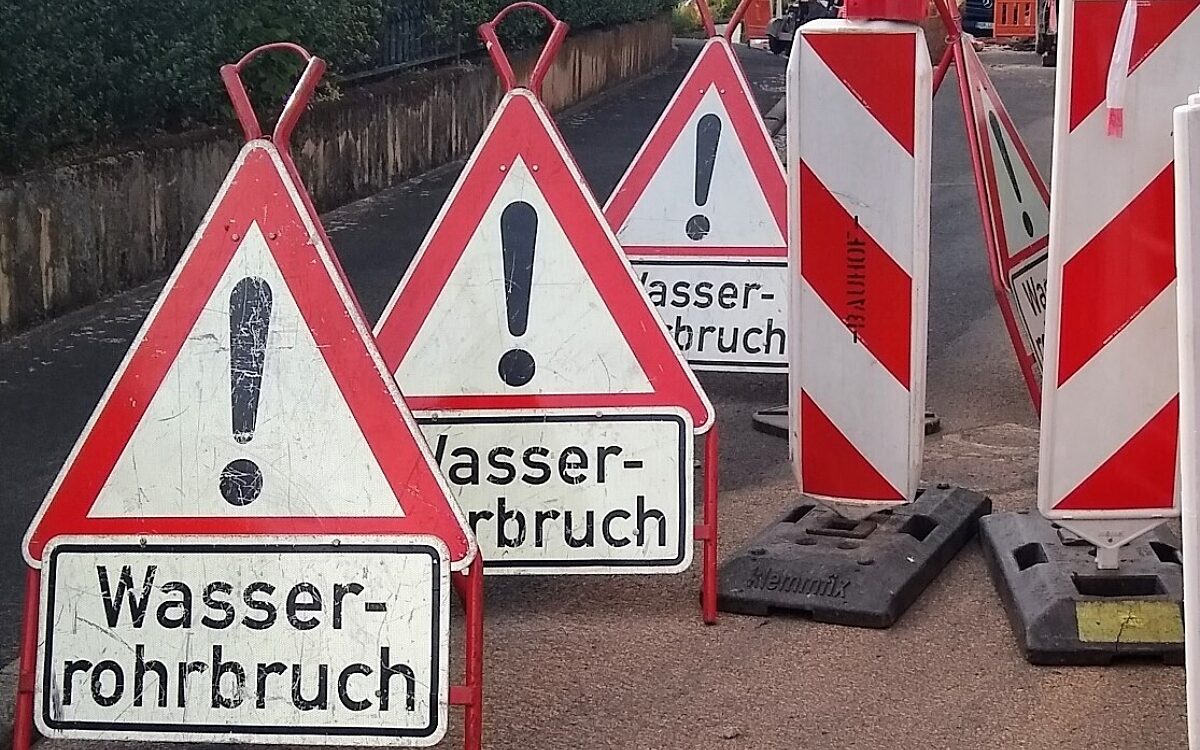 Warnschilder zeigen einen Wasserrohrbruch an Warnschilder zeigen einen Wasserrohrbruch an