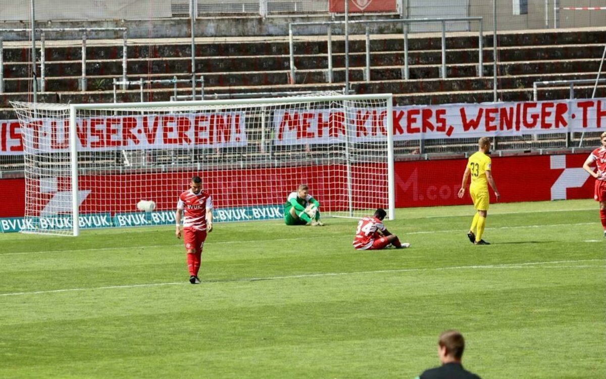 Torwart und zwei spieler der wuerzburger kickers enttaeuscht auf spielfeld Torwart und zwei spieler der wuerzburger kickers enttaeuscht auf spielfeld