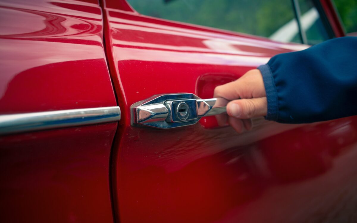 Eine Hand ist am Türgriff eines Autos, um es zu öffnen Eine Hand ist am Türgriff eines Autos, um es zu öffnen