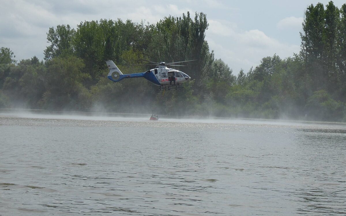 Ein Polizeihubschrauber nimmt Löschwasser auf dem Main auf Ein Polizeihubschrauber nimmt Löschwasser auf dem Main auf