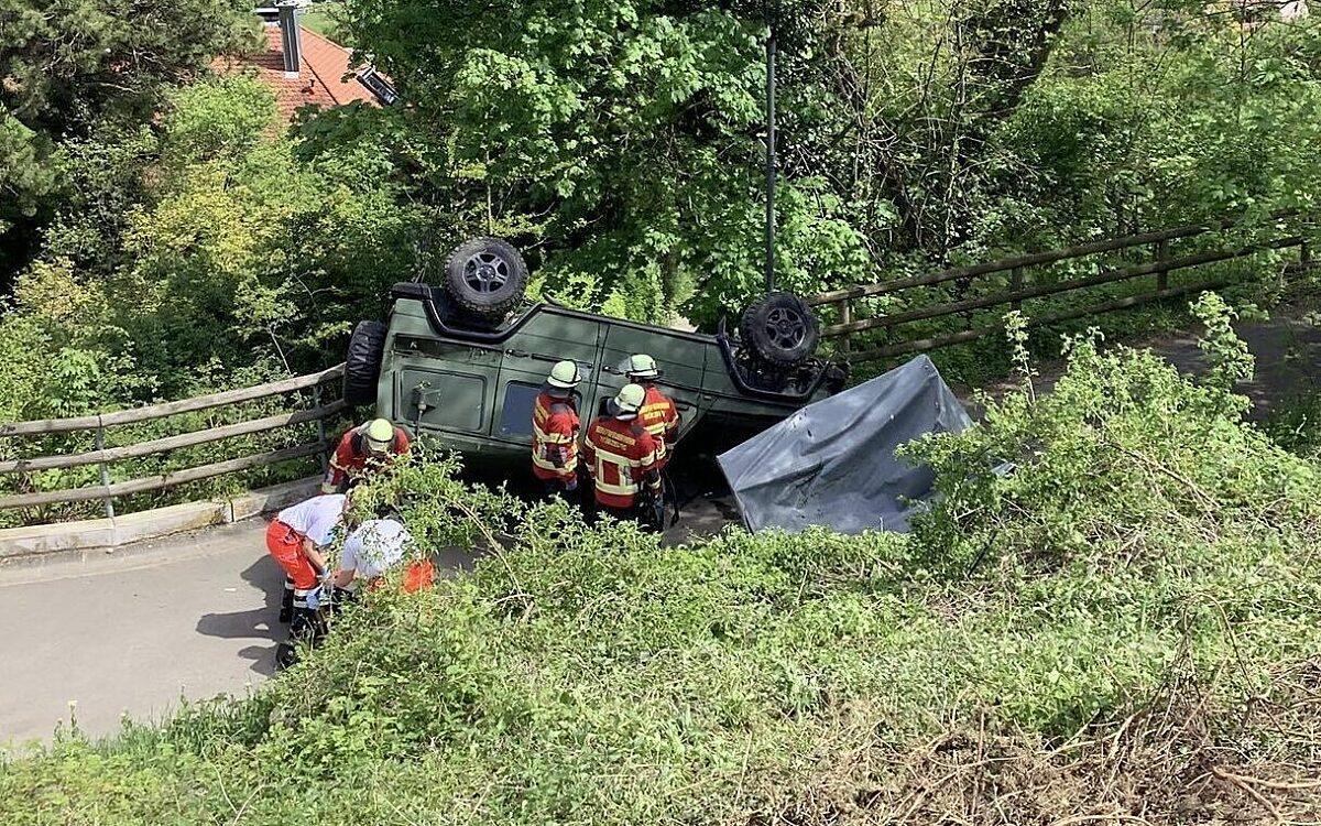 Feuerwehrleute stehen neben dem abgestürzten Geländewagen der Bundeswehr Feuerwehrleute stehen neben dem abgestürzten Geländewagen der Bundeswehr