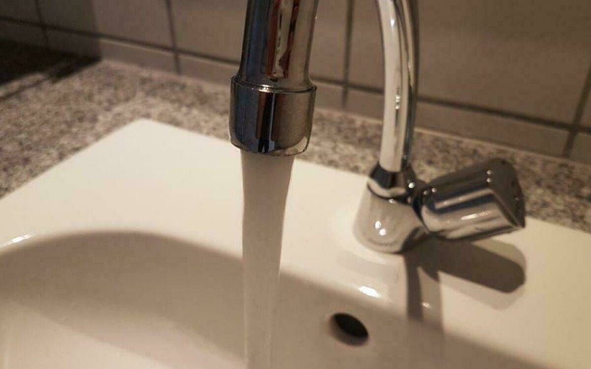 Wasser läuft aus einem Wasserhahn Wasser läuft aus einem Wasserhahn