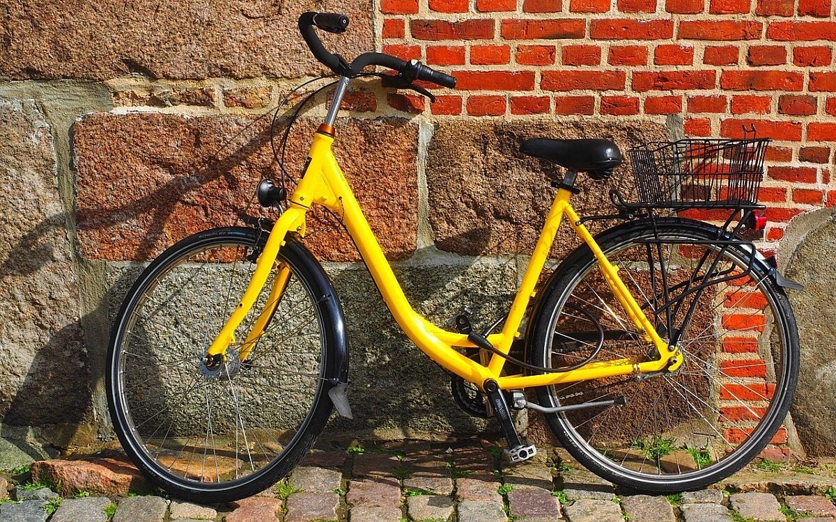 Ein gelbes Fahrrad an einer Mauer Ein gelbes Fahrrad an einer Mauer