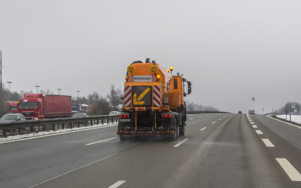 Ein Fahrzeug des Winterdienst streut Salz auf der Autobahn Winterdienst streut Salz Autobahn